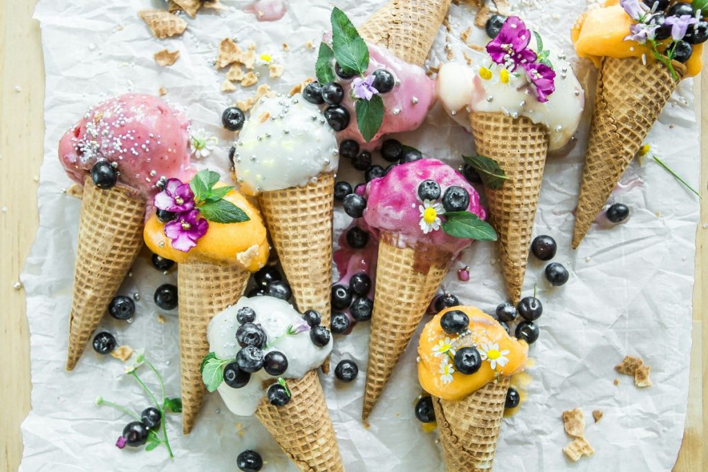 A tantalizing display of Turkish ice cream scoops in vibrant colors, adorned with nuts and fruits, served in traditional style, showcasing Dubai's diverse culinary scene.