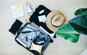 "Illustration depicting essential travel items such as clothing, sunscreen, sunglasses, and a camera, representing items to pack for a trip to Dubai.