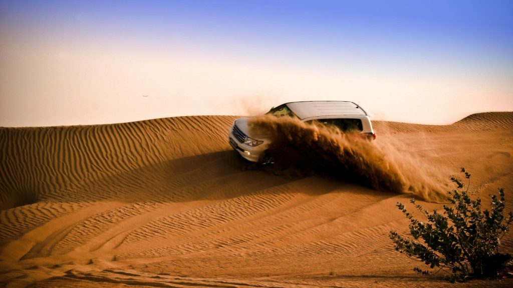 images of people enjoying sandboarding, dune bashing and desserts in Riyadh