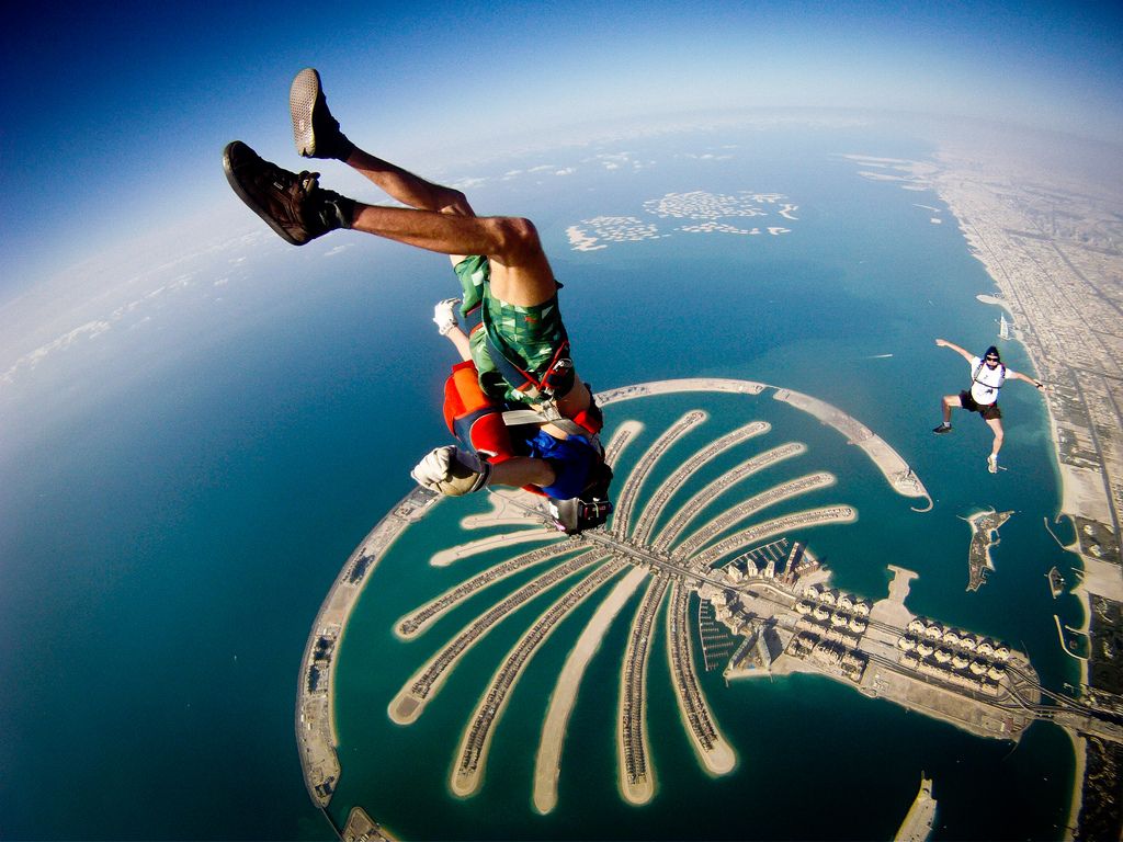 Soaring skydiver against city skyline.